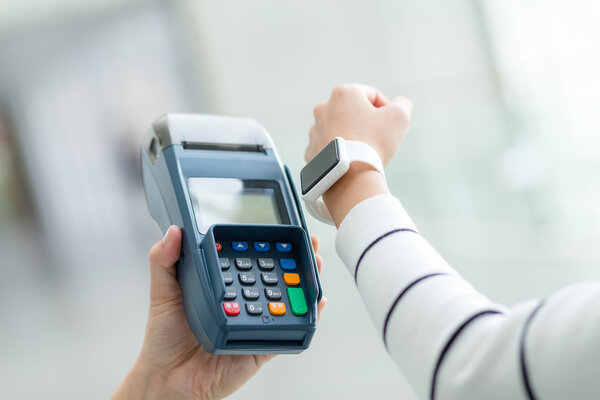 Woman paying the bill by smart watch 