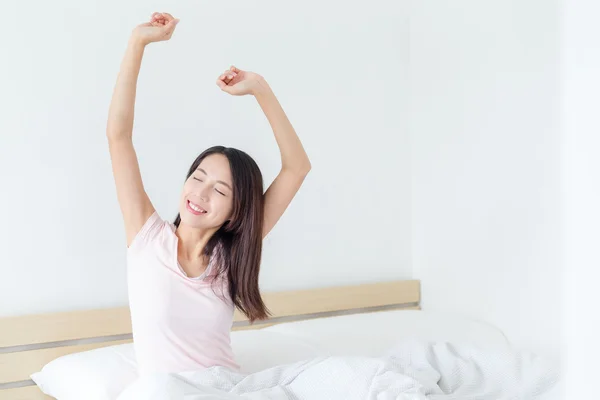 Frau wacht morgens auf und dehnt sich — Stockfoto