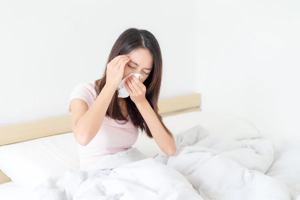 Mulher sentindo dor de cabeça e espirros na cama — Fotografia de Stock