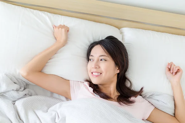 Frau legt sich auf Bett — Stockfoto
