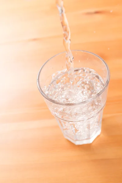 Gieten van water aan het glas — Stockfoto