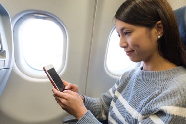 uçak içinde cep telefonu kullanan kadın