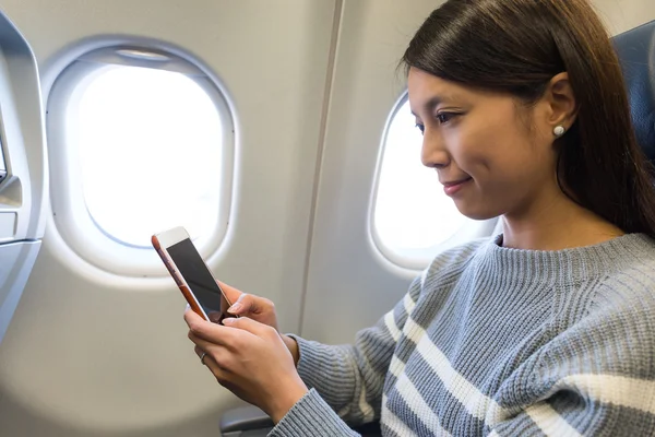 Femme utilisant un téléphone portable à l'intérieur de l'avion — Photo