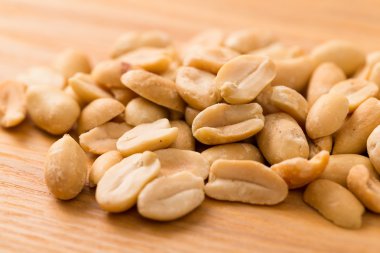 Ahşap masa üzerinde soyulmuş fıstık yığını