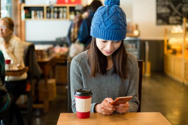 kahve dükkanında cep telefonu kullanan kadın