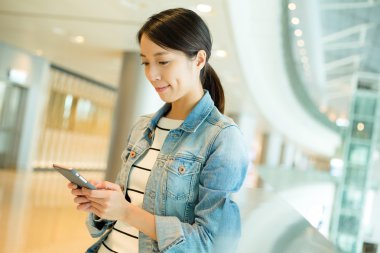 alışveriş merkezinde cep telefonu kullanan kadın