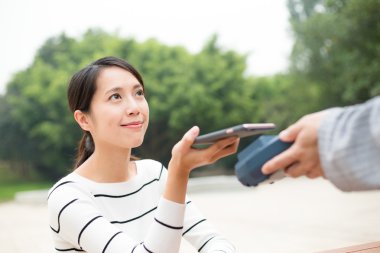 Fatura ödeme için cep telefonu kullanan kadın