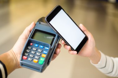 Fatura ödeme için cep telefonu kullanan kadın