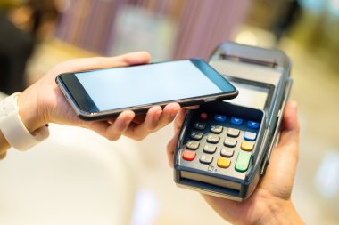 Fatura ödeme için cep telefonu kullanan kadın