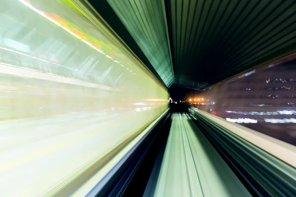 Motion blur of a city and tunnel from inside a moving monorail — Stock Photo, Image