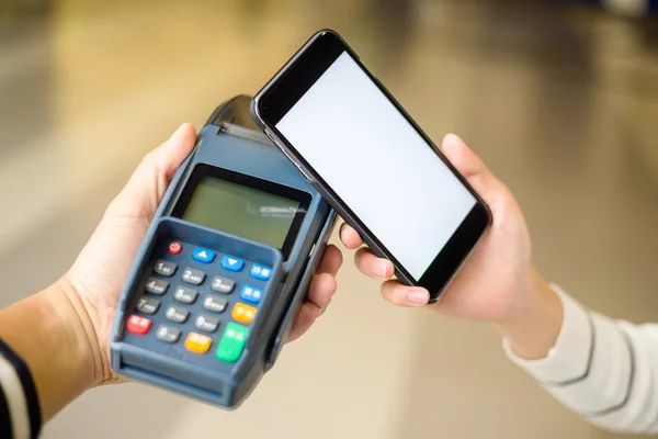 Женщина, использующая мобильный телефон для оплаты счета — стоковое фото