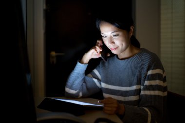 Kadın telefonda konuşurken dijital tablet ile