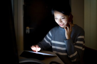 Kadın telefonda konuşurken dijital tablet ile