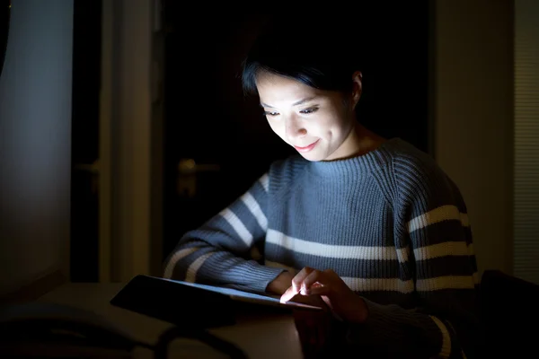 Kvinna med hjälp av TabletPC hemma på natten — Stockfoto