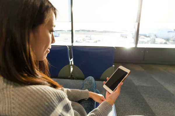 Жінка використовує мобільний телефон в аеропорту — стокове фото