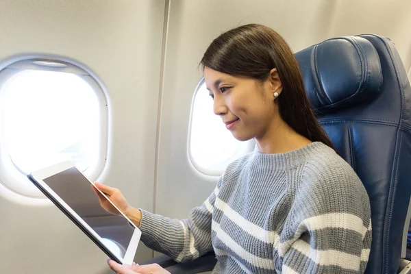 Vrouw met behulp van digitale tablet in vliegtuigen — Stockfoto