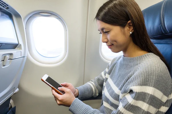 Mulher usando celular dentro de aeronaves — Fotografia de Stock