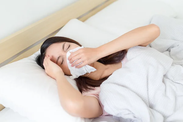 Sick woman sneezing into tissue — Stock Photo, Image