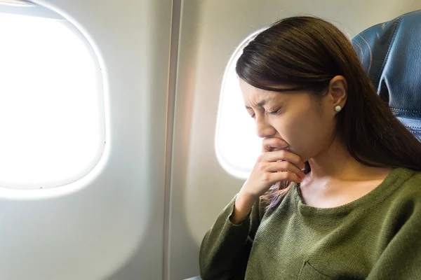 Mulher airsick com dor de cabeça sentado no avião — Fotografia de Stock