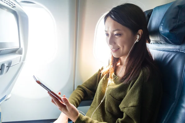 Mujer escuchando música en el avión — Foto de Stock