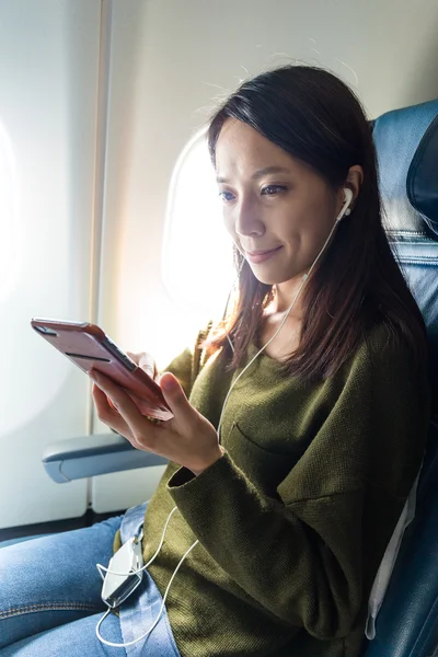 Mujer escuchando música en el avión — Foto de Stock