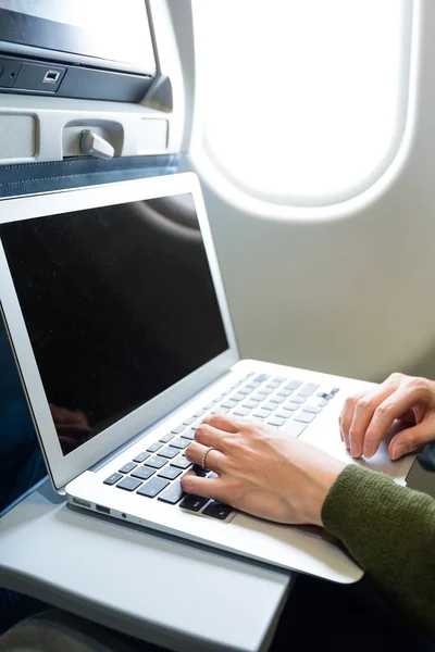 Женщина с ноутбуком в самолете — стоковое фото