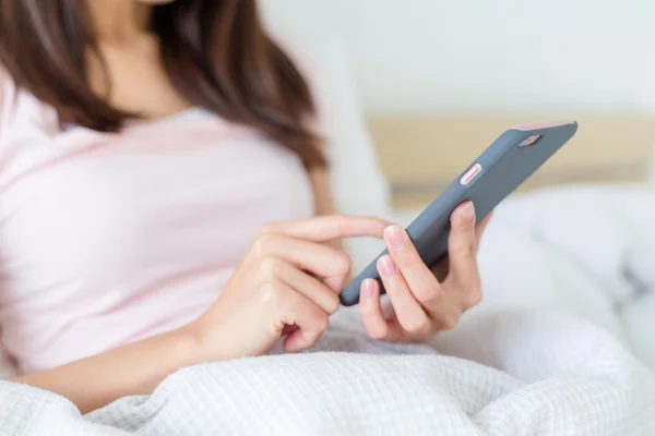 Frau benutzte Handy auf Bett — Stockfoto