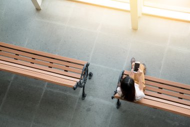 kadın smartphone kullanarak bankta