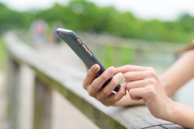 parkta cep telefonu kullanan kadın