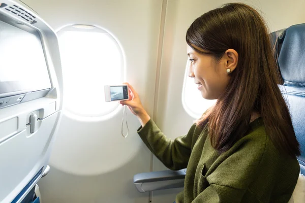 Mujer tomando fotos por la ventana — Foto de Stock