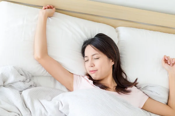 Женщина спит в белой кровати — стоковое фото