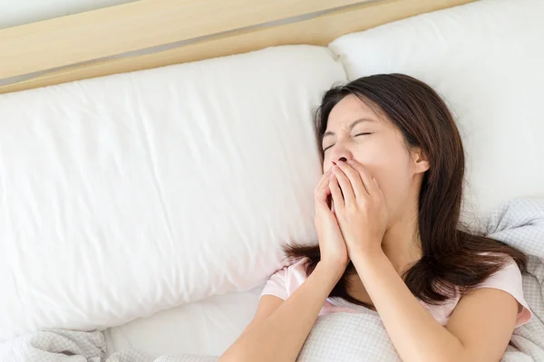 Zieke vrouw in bed blazen haar neus — Stockfoto