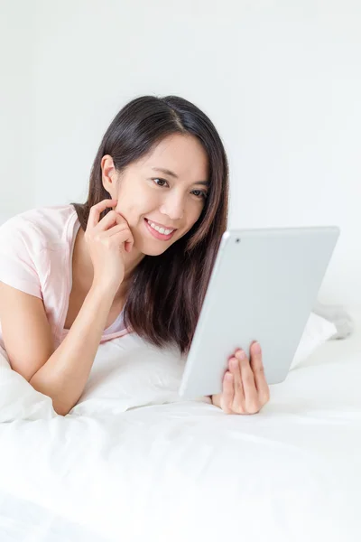 Frau mit digitalem Tablet auf dem Bett — Stockfoto