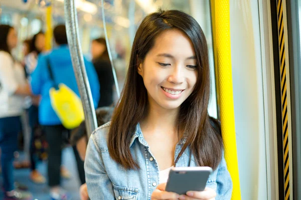 Woman using cellphone in train compartment — Stock Photo, Image