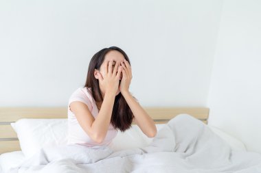 yatakta kadın esneme oturma