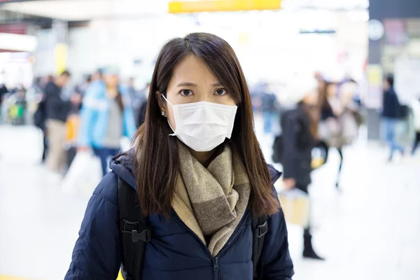 Vrouw draagt gezichtsmasker op treinstation — Stockfoto