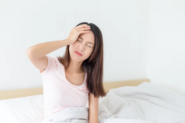 Женщина чувствует головную боль на кровати дома — стоковое фото