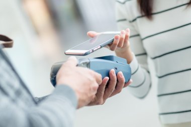 Fatura ödeme için cep telefonu kullanan kadın