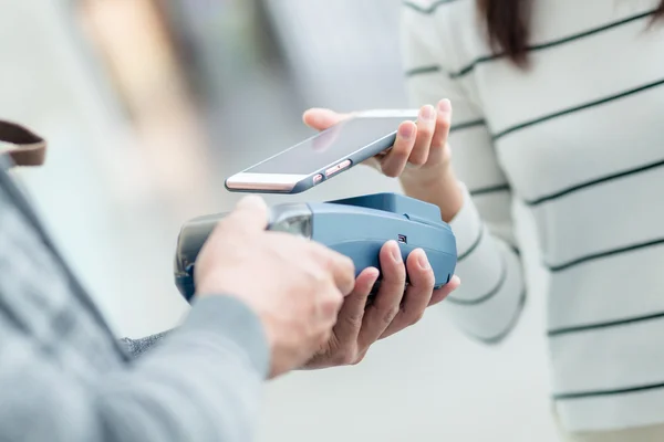 Mujer usando el teléfono celular para pagar la factura — Foto de Stock