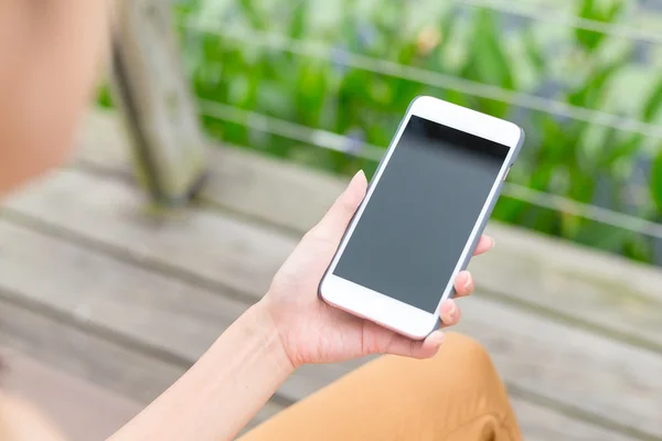 Mujer sostiene teléfono móvil — Foto de Stock