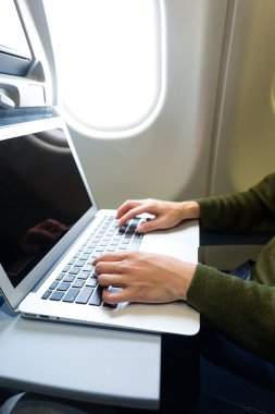 Uçak içinde laptop üzerinde çalışan kadın