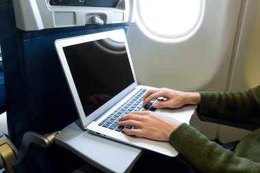 Uçak içinde laptop üzerinde çalışan kadın