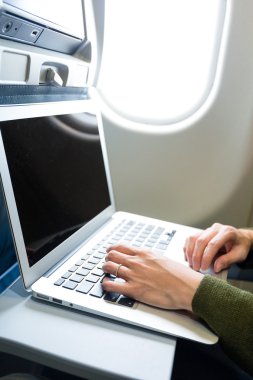 Uçak içinde laptop üzerinde çalışan kadın