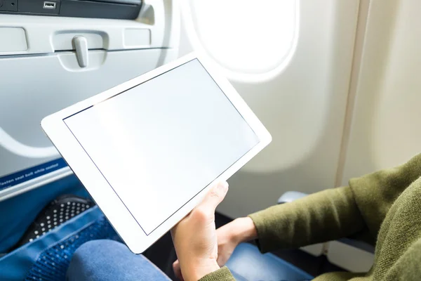 Vrouw met behulp van de tablet in vliegtuig — Stockfoto