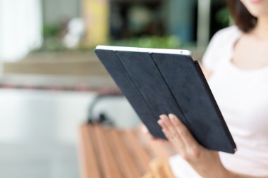 Tablet kullanan genç bir kadın.