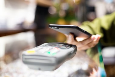 Fatura ödeme için cep telefonu kullanan kadın