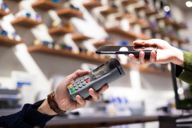 Fatura ödeme için cep telefonu kullanan kadın