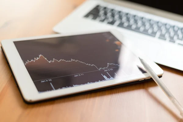 Digital tablet with business charts on a screen — Stock Photo, Image