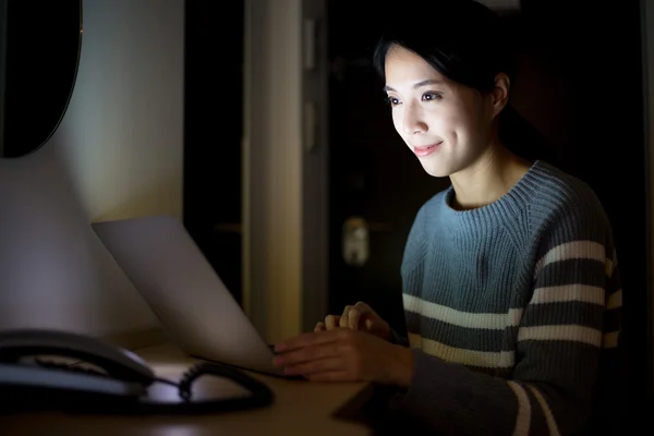 Γυναίκα που εργάζεται επάνω μικρόs φορήτοs υπολογιστήs τη νύχτα — Φωτογραφία Αρχείου