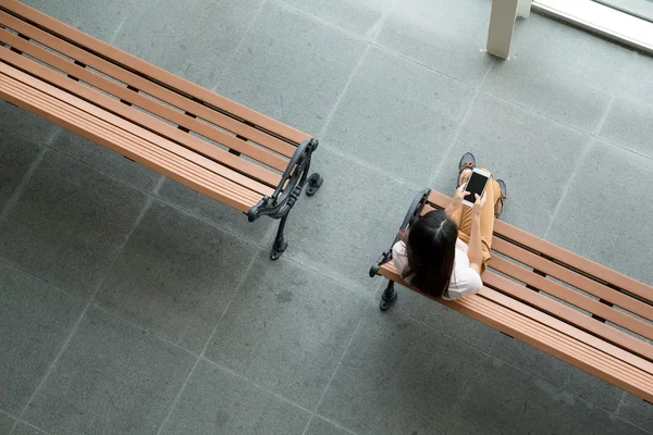 Kadın smartphone kullanarak bankta — Stok fotoğraf